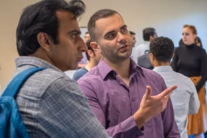 students discussing economics at a poster session