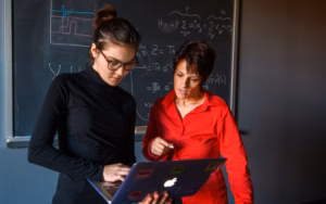 Physics professor with student looking over laptop
