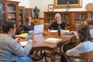 students and faculty converse around a table