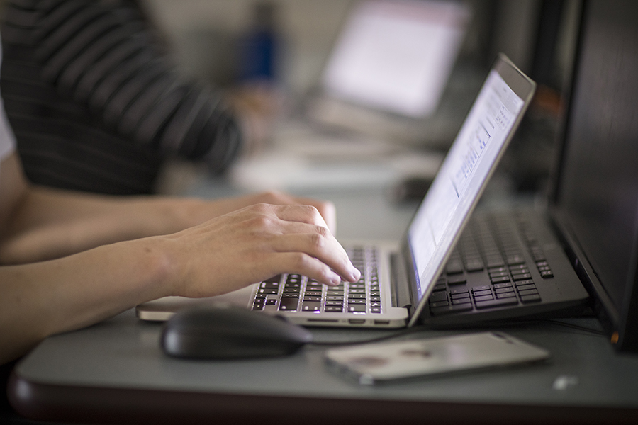student's hands on laptop