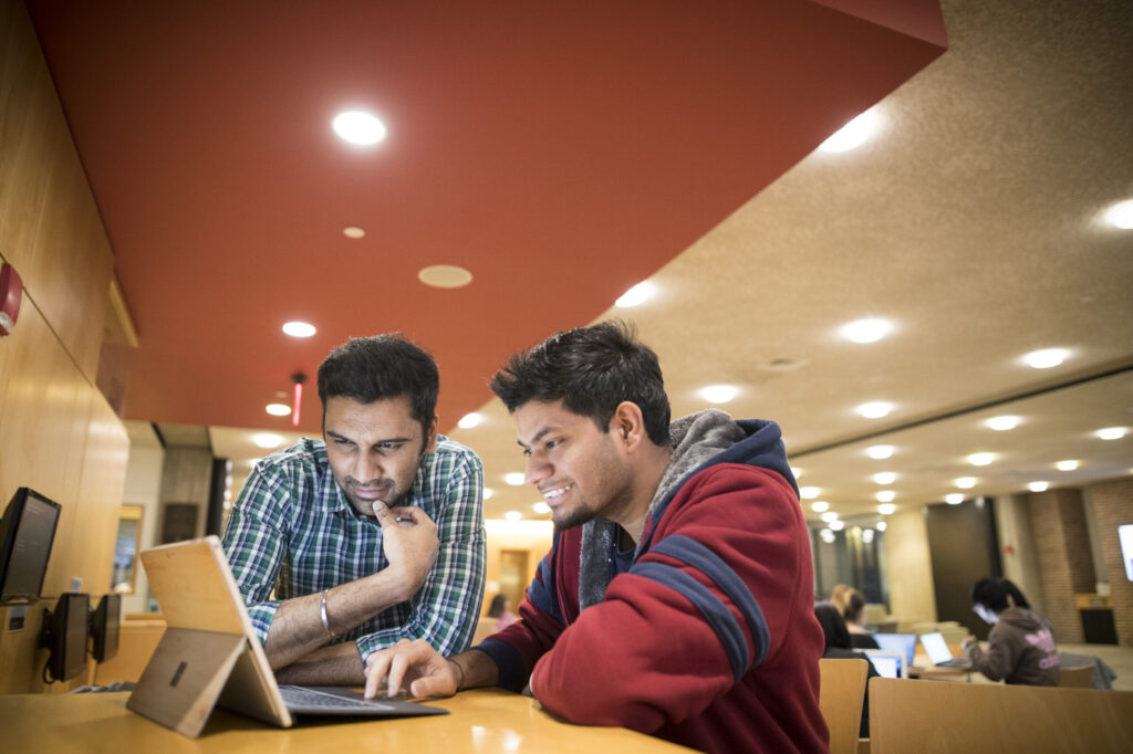 graduate students sitting in front of laptop