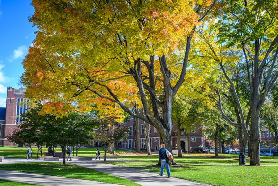 geography building with student walking across campus