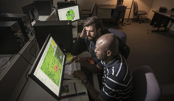 two males looking at heat maps