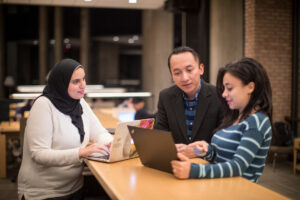 graduate students looking at pc