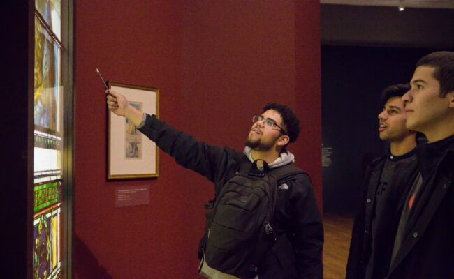 students looking at art on wall