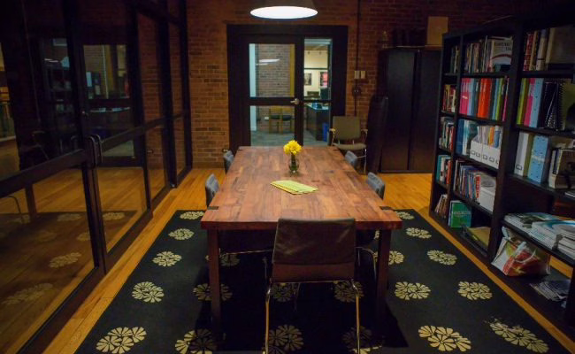 wooden table with bookshelf next to it.