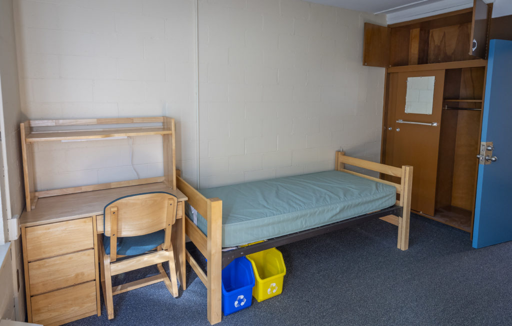 dorm room setting with bed and desk