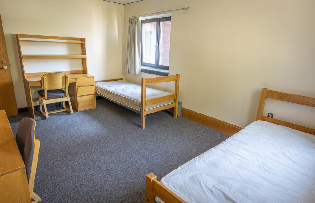 dorm room with beds and desk