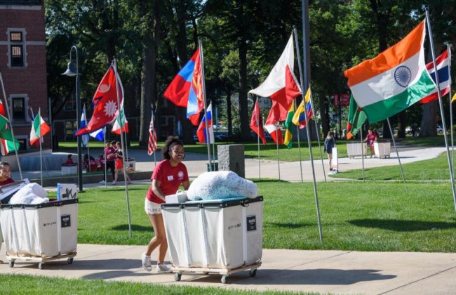 girl pushing cart of supplies on move in day