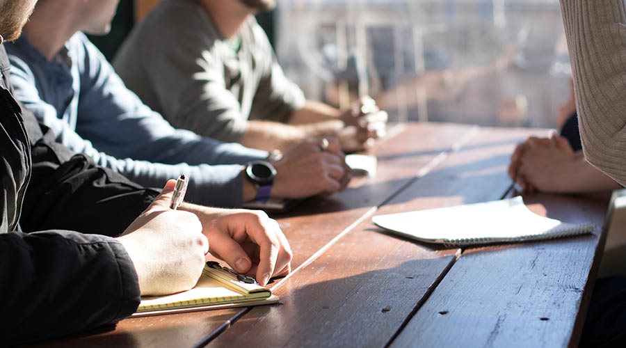 People sitting around a table with computers to signal work and internships