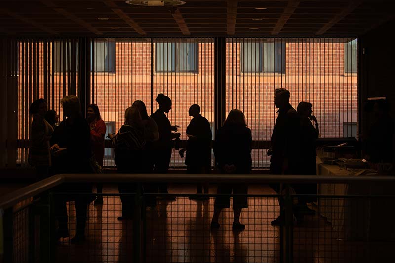 A silhouetted group of people from a lecture on the Clark campus