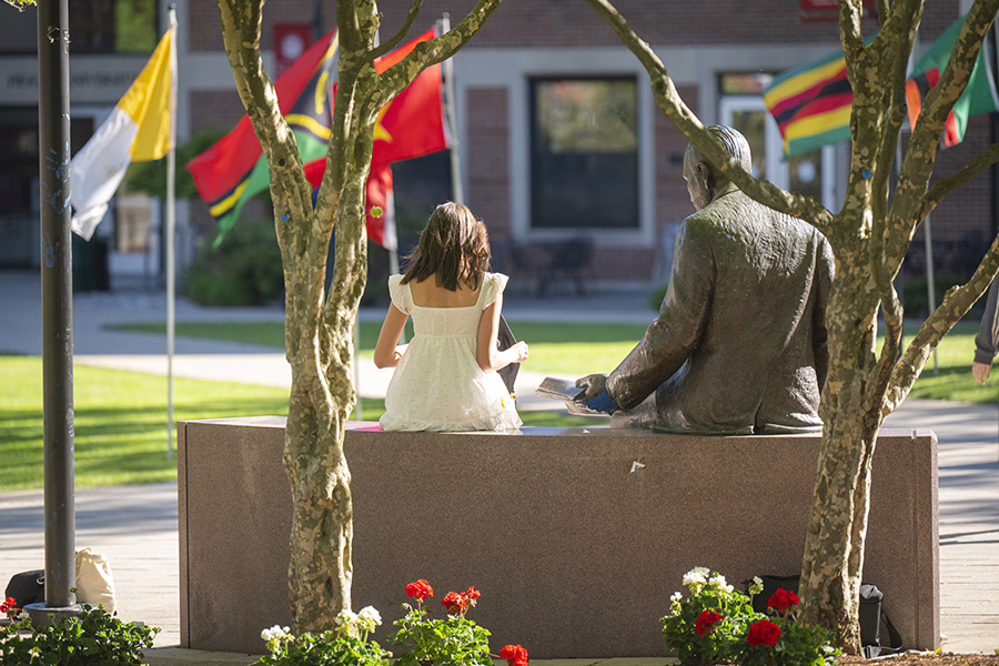 girl sitting next to statue