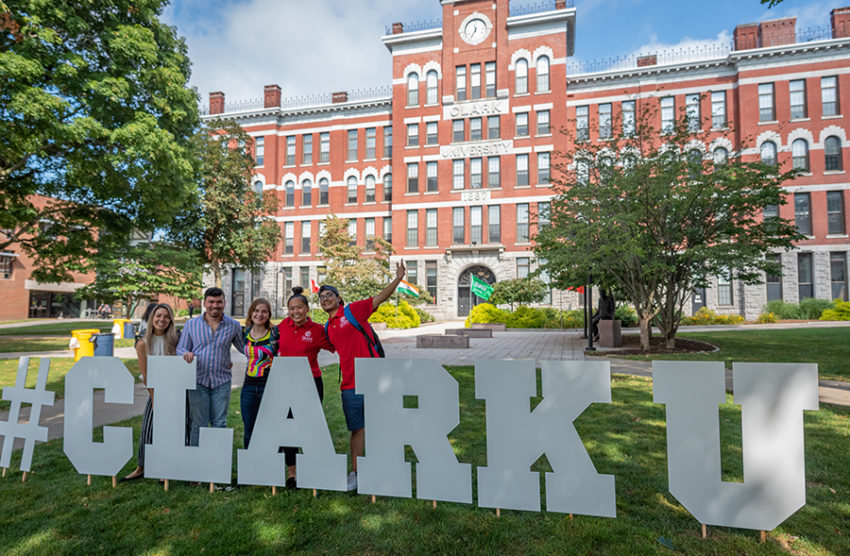 clarku hash tag sign with students