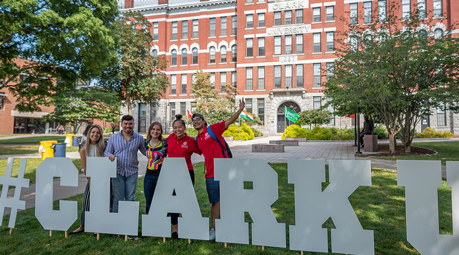 students behind clarku has tag sign