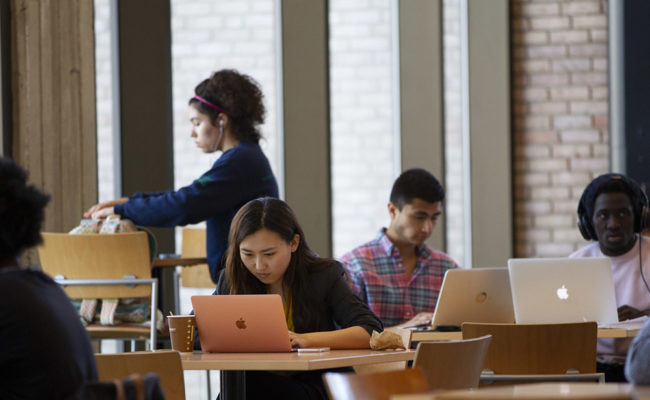 students studying at desks in library