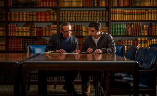 Professor and student looking at books