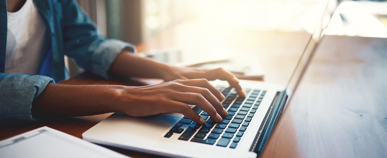 Hands typing on a computer