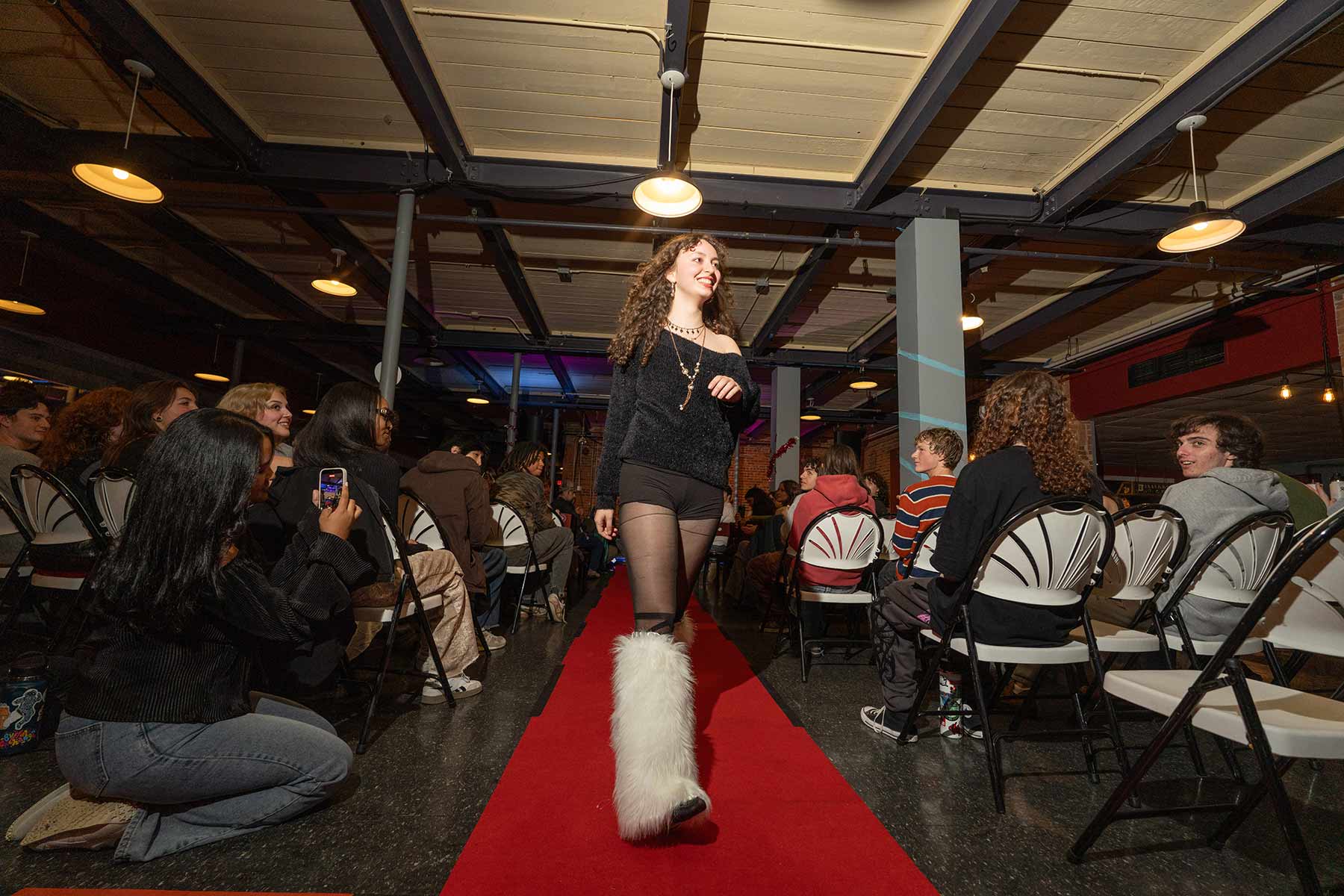 A student participating in a thrift store fashion show, Clark University