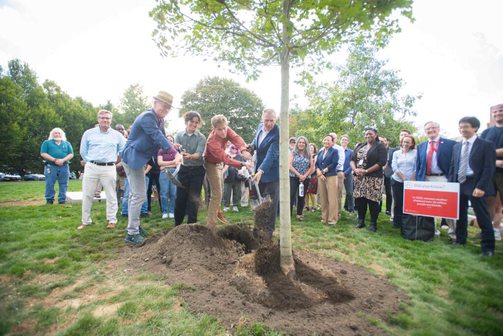 Dean Lou Leonard and President David Fithian, with Ruby Lichtman ’27 and Zach Rutherford ’27, plant a red maple by the Shaich family Alumni and Student Engagement Center at the kick-off celebration of the new School of Climate, Environment, and Society