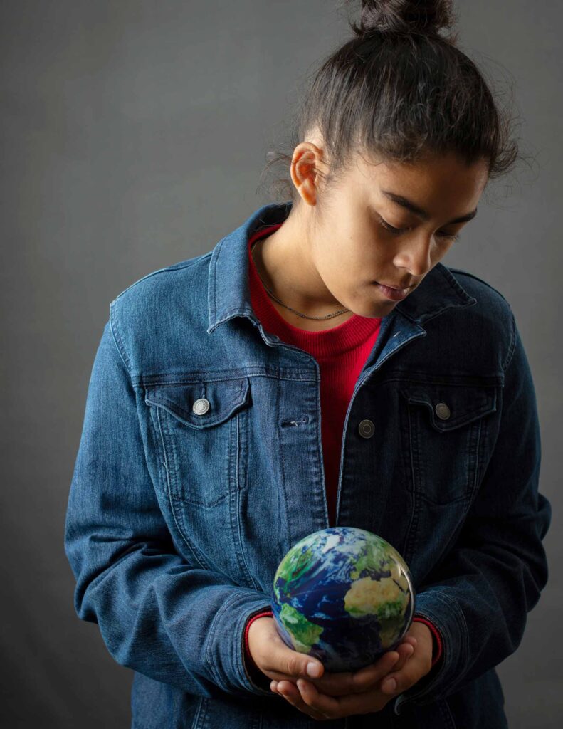 Ava Soch ‘28 poses for a cover shot for the magazine, holding a glass globe.