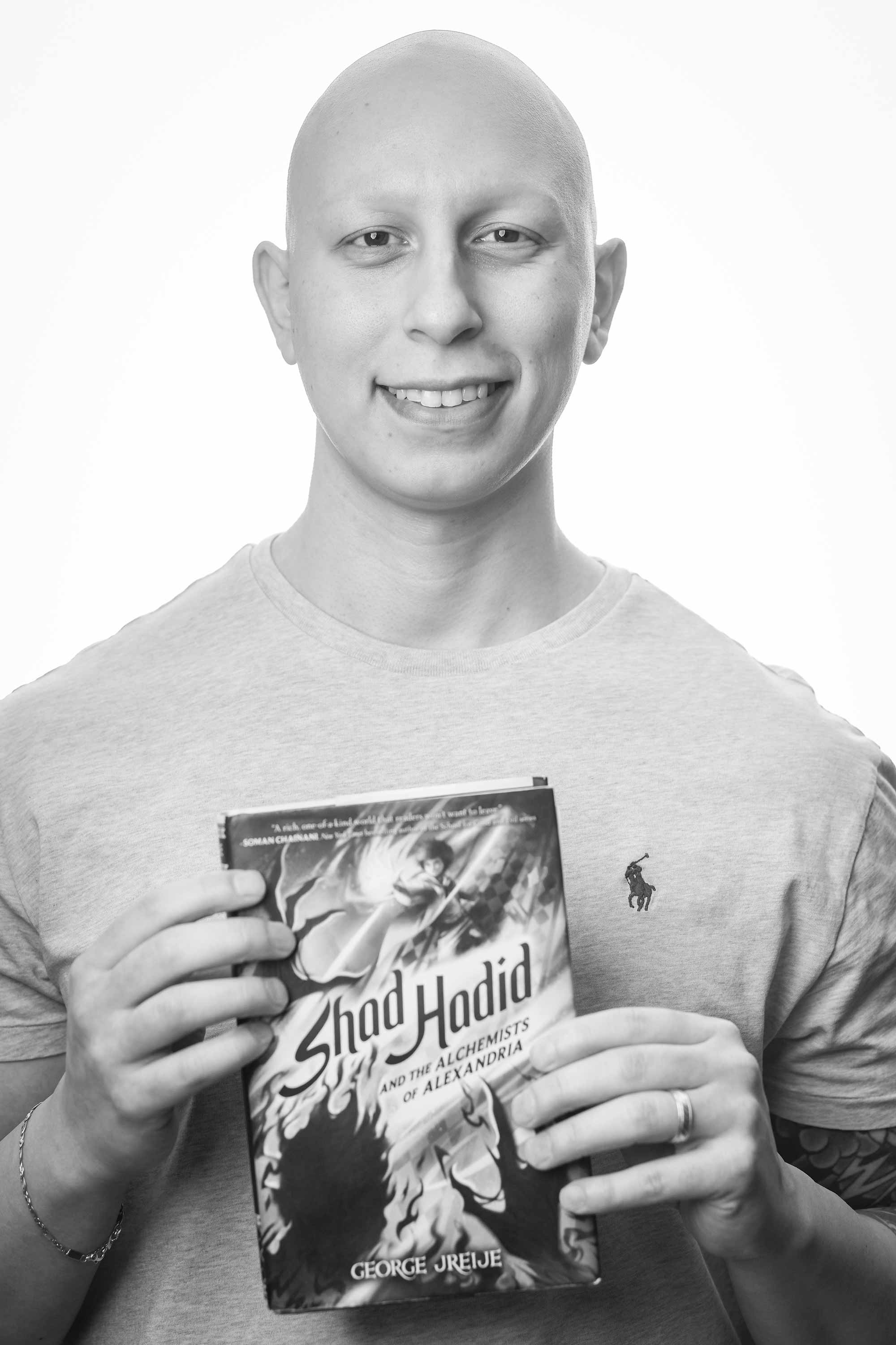 Fantasy writer George Jreije '17, MBA '18 holding his novel, Shad Hadid and the Alchemists of Alexandria
