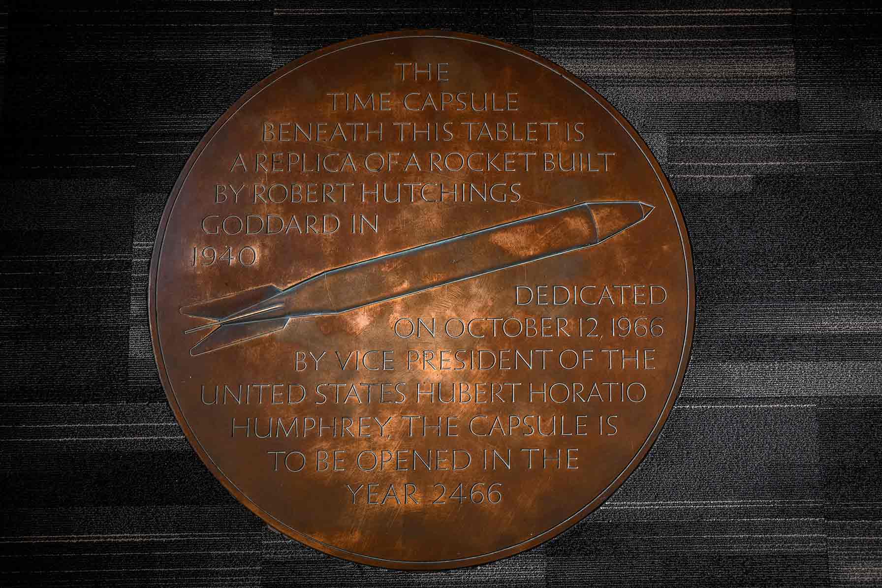Time capsule marker, Goddard Library with the following inscription: The time capsule beneath this tablet is a replica of a rocket built by Robert Hutchings Goddard in 1940 dedicated on October 12, 1966 by Vice President of the United Stated Hubert Horatio Humphrey. The capsule is to be opened in the year 2466.