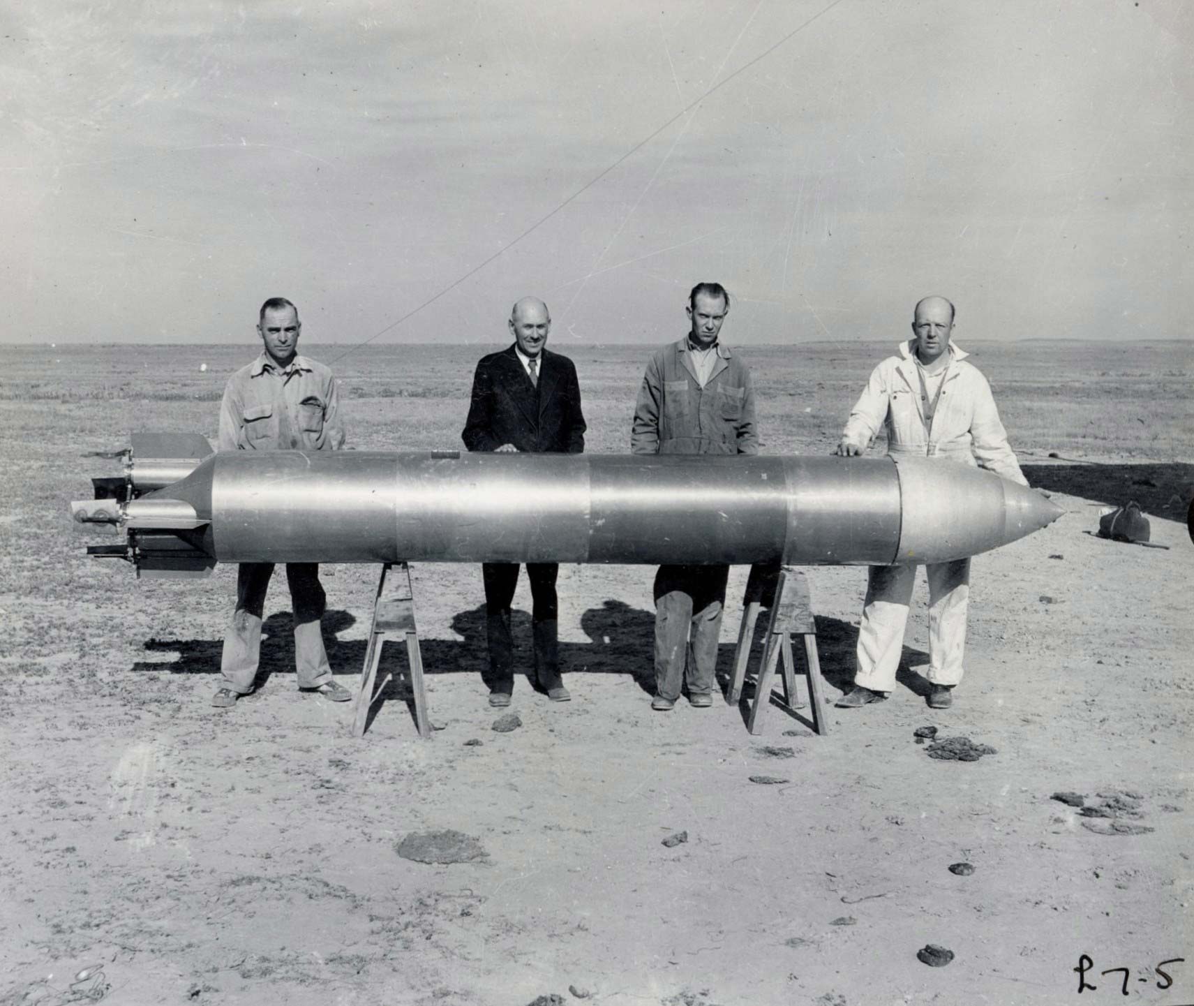 Robert Goddard and his team carry a rocket as they prepare for a launch in the New Mexico desert.