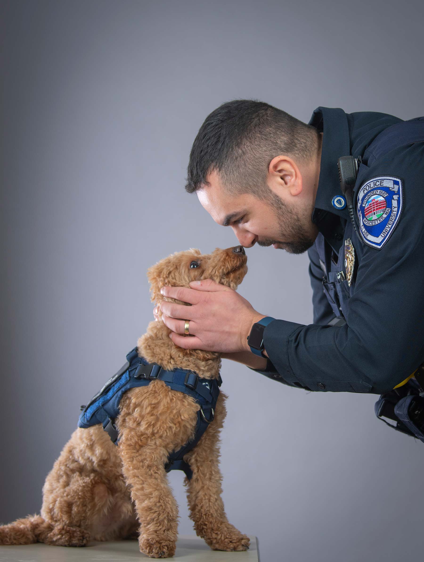 Detective Evan Gaylord of the Clark University Police Department touches noses with Mango, their newest recruit.