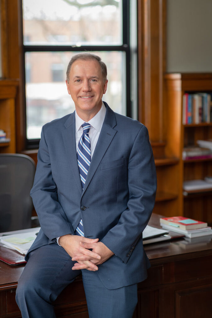 President David B. Fithian ‘87 sitting on a desk in his office