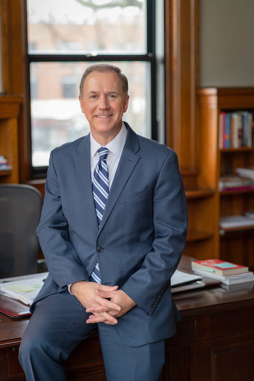 President David B. Fithian ‘87 sitting on a desk in his office