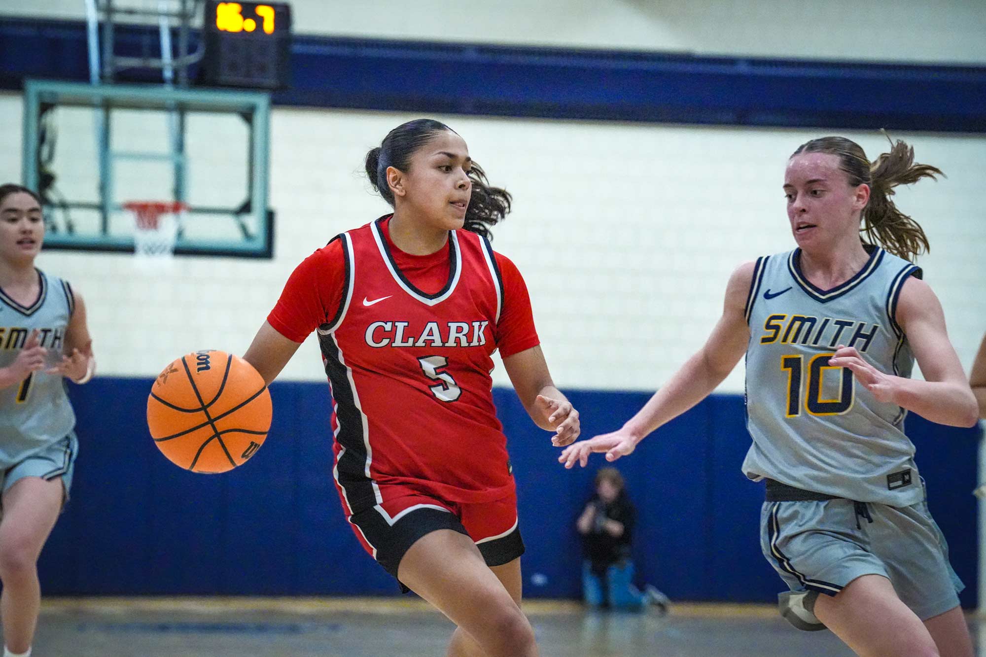 NEWMAC champion women's basketball team member dribbling the ball past a member of the opposing team, 2026