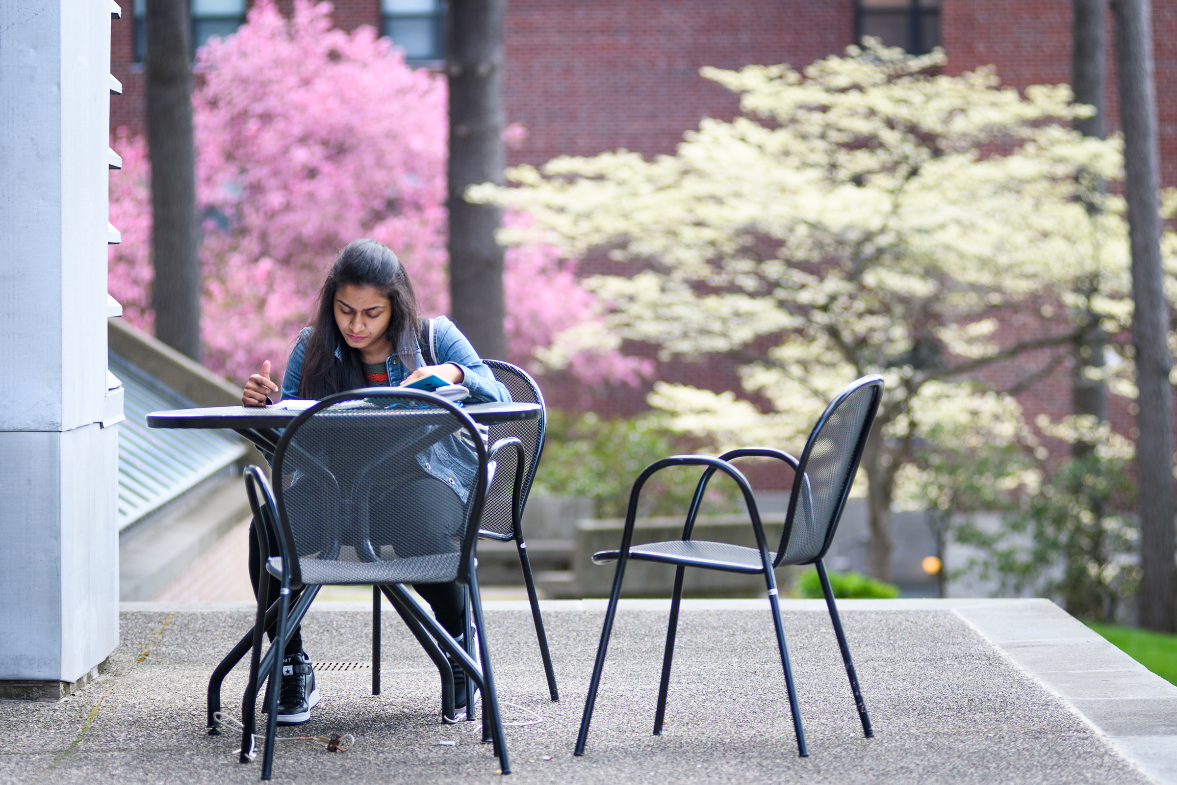 Goddard Library - girl sitting outside with chairs/tables