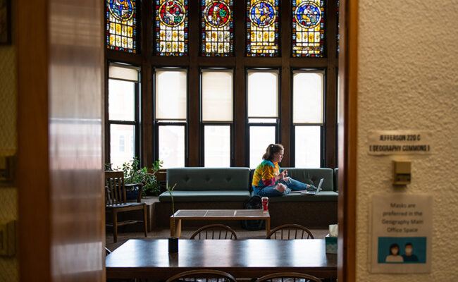 Geography Building stained glass with girl sitting under it