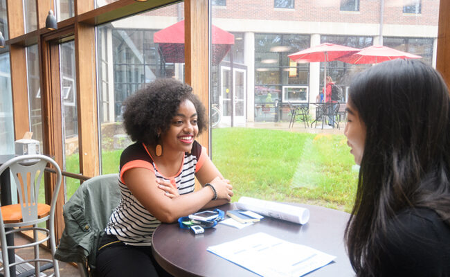 Higgins University Center - two students eating and talking at table