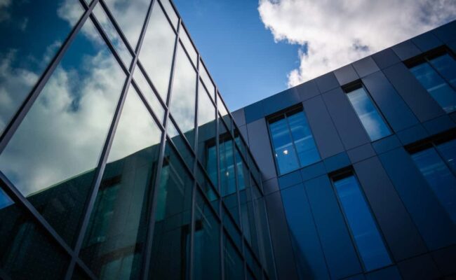 windows of the building reflecting the clouds and blue sky