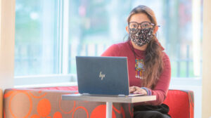 Aandishah Tehzeeb Samara sitting behind laptop