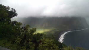 Waimea Valley Hawaii Overlook Foggy view of Coast. Heavy cloud cover of fertile utopian paradise valley from top of mountain with mountains in the distance. Fertile Utopian Valley where Kings meet