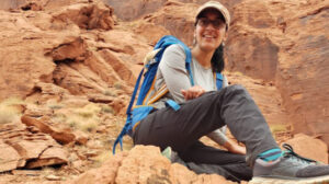 Student sitting on desert rock