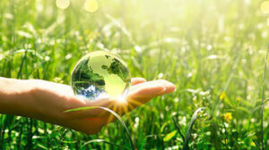 hand holding large water drop in field