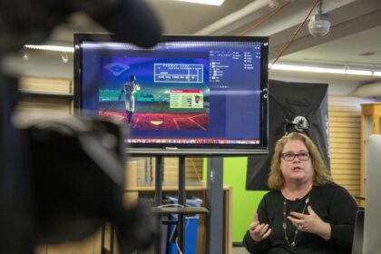 professor next to tv screen