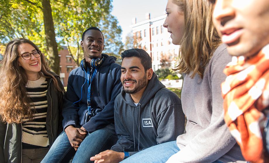 student workers sitting on stone wall