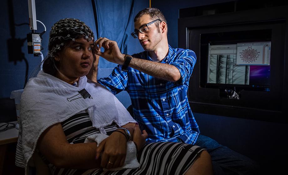 Sherief Eldeeb ’18 demonstrates how he attaches electrodes to a person's scalp