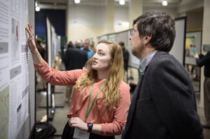 Female pointing to white board to male teacher