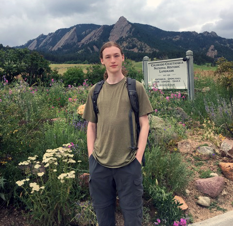 Clement Nagourney stands in field near mountains