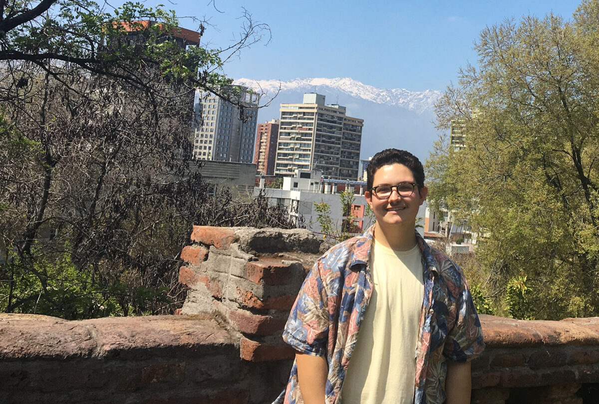 Max DeFaria standing in front of a wall overlooking the city in Chile