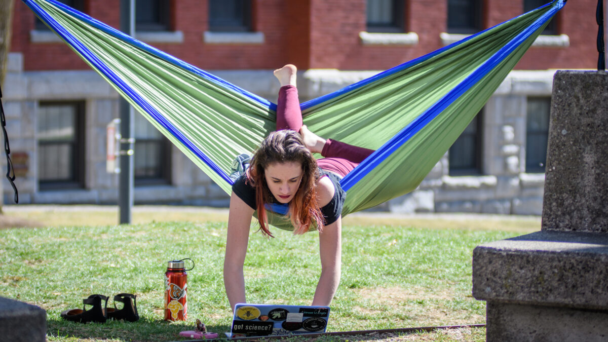 Student relaxes in a hammock on the campus green