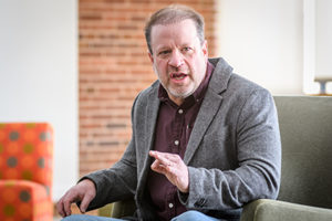 John Morano sitting infront of audience in casual setting