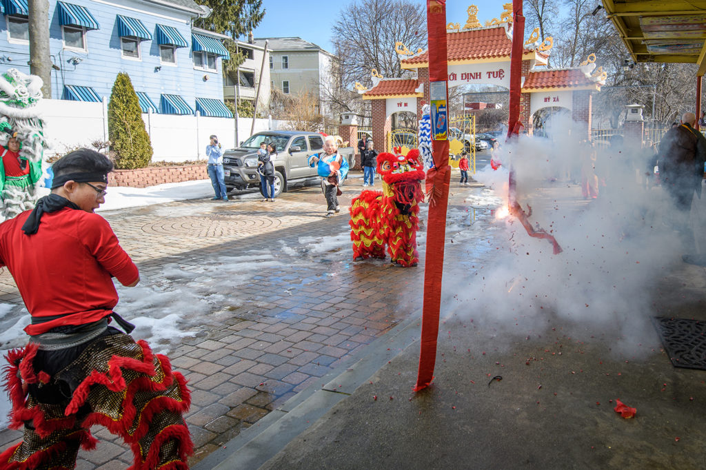 Man setting off fireworks on Lunar New Year near Clark campus