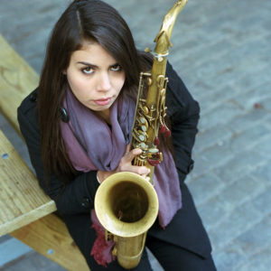 Melissa Aldana holding saxophone