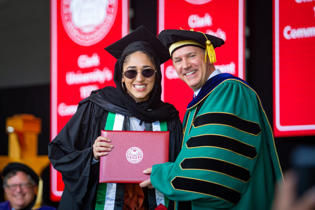 President David Fithian presents a student with a diploma at the 2021 Commencement